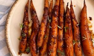 zanahorias glaseadas al horno con miso y miel y hierbas de la huerta por encima con mantel rayado blanco y celeste