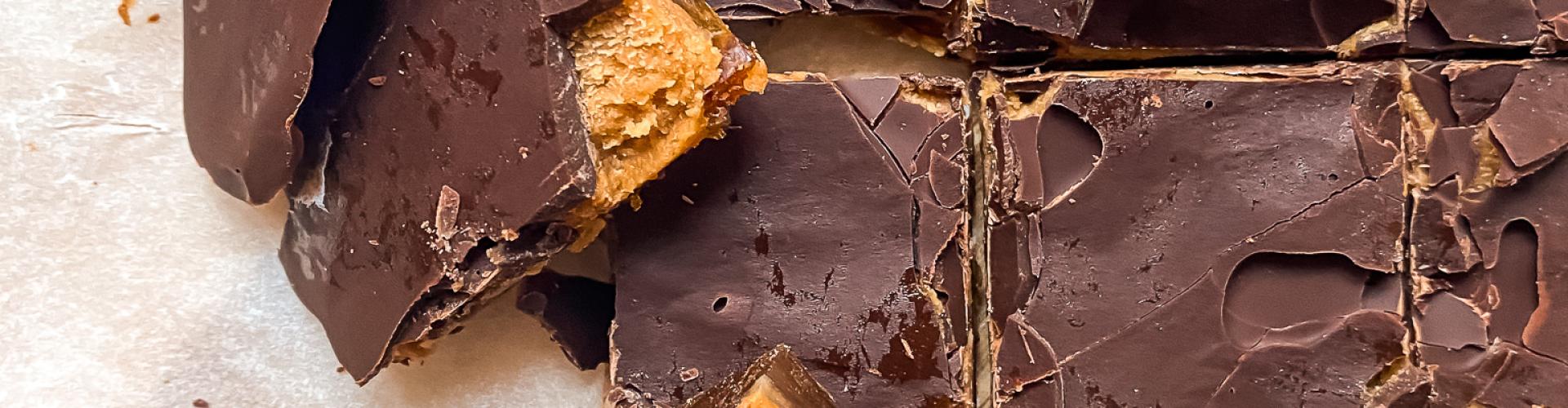 Bombones de miso con crema de maní, dátiles y chocolate negro cortados en cuadrados sobre papel manteca